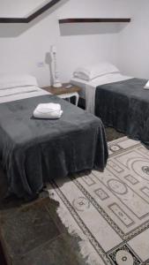Habitación con 2 camas y alfombra. en Almas gêmeas quarto casal en Angra dos Reis