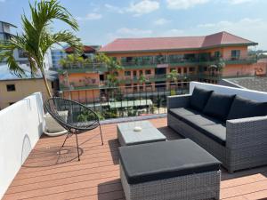 芭達雅中心的住宿－ONE LODGE Pattaya，阳台配有沙发、椅子和桌子