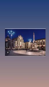 a large building with a tower in front of it at night at Fortino vecchio apartment in Catania