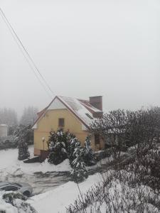 a house with snow on the roof of it at U Zbyszka in Kamienna Góra