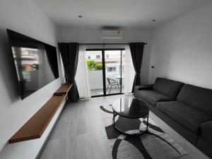 ein Wohnzimmer mit einem Sofa und einem Glastisch in der Unterkunft ONE LODGE Pattaya in Pattaya