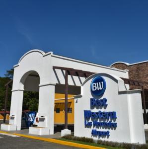 un bâtiment avec un panneau indiquant le meilleur ouest du bus dans l'établissement Best Western Las Mercedes Airport, à Managua