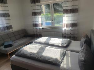 ein Wohnzimmer mit einem Bett und einem Sofa in der Unterkunft Katjas Ferienwohnungen in Giebelstadt
