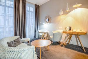 une chambre d'hôtel avec des chaises, une table et un bureau dans l'établissement Vallier Suite n18 - Exceptional suite in Bordeaux - Welkeys, à Bordeaux