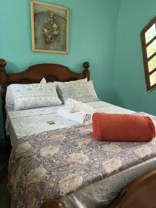 uma cama num quarto com uma parede azul em Recanto das Margaridas em Ilhabela