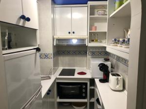 マルベーリャにあるApartamento Marbella Centroの小さなキッチン(白いキャビネット、電子レンジ付)