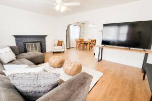 uma sala de estar com um sofá e uma televisão de ecrã plano em Cozy and Spacious Home in Ogden em Ogden