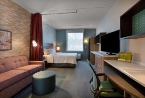 Habitación de hotel con cama y sofá en Home2 Suites By Hilton Charlotte Belmont, Nc en Belmont