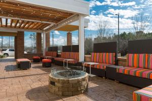 eine Terrasse mit Sofas und einer Feuerstelle in der Unterkunft Home2 Suites By Hilton Charlotte Belmont, Nc in Belmont
