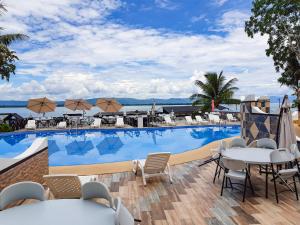 a large swimming pool with chairs and tables next to a building at Hotel Mi Paraíso Río Dulce in San Felipe