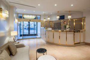 a living room with a couch and a counter at Hotel Camille Paris Tapestry Collection by Hilton in Paris