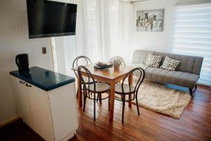 a living room with a table and chairs and a couch at Leftraro Lodge Urbano in Villarrica