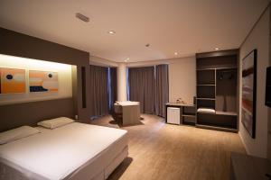 Schlafzimmer mit einem Bett, einem Schreibtisch und einem Waschbecken in der Unterkunft Zahara Hotel in Limeira