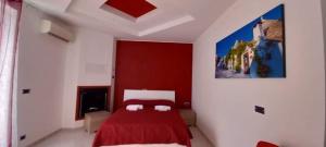 - une chambre avec un lit rouge et un tableau mural dans l'établissement Agriturismo Liscio, à Noci