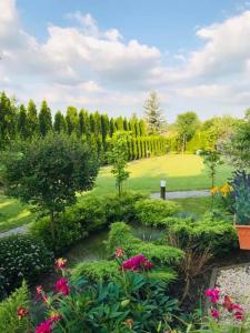 un jardín con flores, árboles y un campo en Luxury Villa - JessApart Walendia, en Walendów