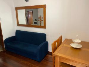 una silla azul, una mesa y un espejo en Gerês River - Apartamento na Natureza, en Gerês
