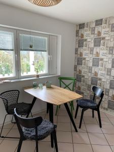 a dining room with a wooden table and chairs at Maison Grande Fleur in Metterich