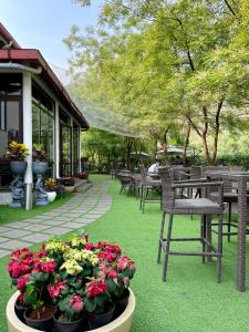 a patio with chairs and flowers on the grass at The Greenwood Resort, Guwahati in Guwahati