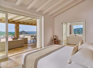 a bedroom with a bed and a view of the ocean at Conrad Chia Laguna Sardinia in Chia