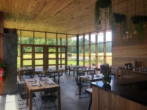 um restaurante com mesas e cadeiras numa sala com janelas em Mawün Lodge em Villarrica