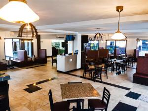 a restaurant with tables and chairs in a room at Hotel Mi Paraíso Río Dulce in San Felipe