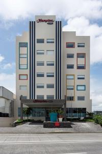 un gran edificio blanco con un cartel. en Hampton by Hilton Veracruz Boca Del Rio, en Veracruz