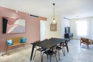 comedor con mesa y sillas en Spacious 3BR in Neve Tzedek by HolyGuest, en Tel Aviv