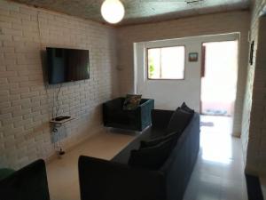a living room with a couch and a tv at Pousada Morro da Baleia in Alto Paraíso de Goiás
