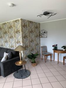 ein Wohnzimmer mit einem Sofa und einem Tisch in der Unterkunft Maison Grande Fleur in Metterich