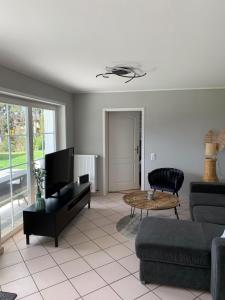 ein Wohnzimmer mit einem Sofa und einem Tisch in der Unterkunft Maison Grande Fleur in Metterich