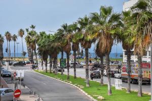 una calle con palmeras al lado de una carretera en Spacious 3BR in Neve Tzedek by HolyGuest, en Tel Aviv