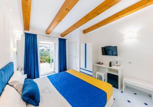 Un dormitorio con una cama azul y amarilla y una ventana en La Margherita Fiorita, en Ravello