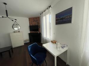 een woonkamer met een blauwe stoel en een wit bureau bij Duplex quartier Saint-Sernin, Toulouse in Toulouse