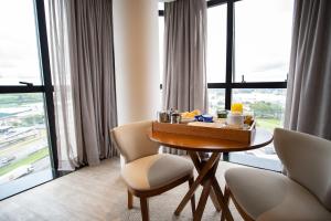 um quarto com uma mesa e cadeiras e uma grande janela em Zahara Hotel em Limeira