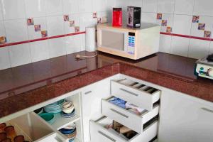 a kitchen with a counter top with a microwave at Villa Rumah Oma Lembang 4 Kamar Strategis in Bongkor 1