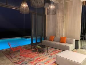 a living room with a couch and a pool at Eolia Sustainable Design Hotel in Manta