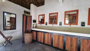 uma casa de banho com um balcão com armários de madeira e espelhos em Totem Buenavista em Bacalar