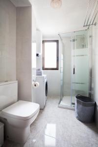 a white bathroom with a toilet and a shower at Hola Mar in Torrevieja +39 photos