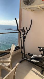 a gym with two chairs and a fan and the ocean at شقة فندقية فاخرة luxury apartment sea view in Alexandria
