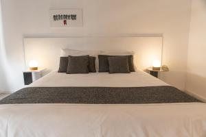 a bedroom with a large white bed with two lamps at Babel Nueva Córdoba in Cordoba