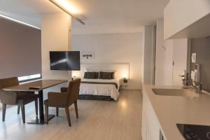 Habitación de hotel con cama, mesa y sillas en Babel Nueva Córdoba en Córdoba