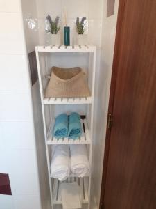 a white towel rack with towels in a bathroom at The Windhouse in São Bartolomeu