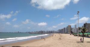 una playa con gente y edificios y el océano en Porto de Iracema, en Fortaleza