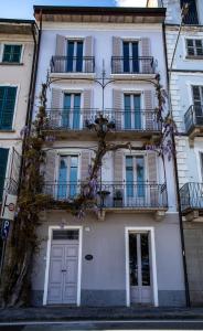 um edifício branco alto com varandas e uma porta em La dimora del Glicine 2 em Belgirate
