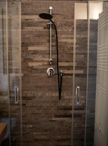 um chuveiro na casa de banho com uma parede de madeira em La dimora del Glicine 2 em Belgirate