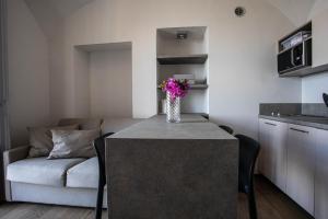 uma cozinha com uma mesa com um vaso de flores em La dimora del Glicine 2 em Belgirate