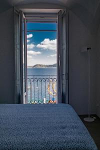Un dormitorio con una cama y vista al mar. en La dimora del Glicine 2, en Belgirate