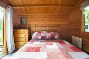 a bedroom with a bed in a wooden cabin at Tui Ridge Eco Cabins in Aongatete