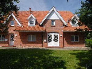 a brick house with an orange roof at Haus-Am-Sommerdeich-Whg-12 in Sankt Peter-Ording