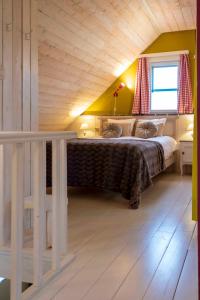 a bedroom with a large bed with a wooden ceiling at Gîte les Mineurs in Zottegem